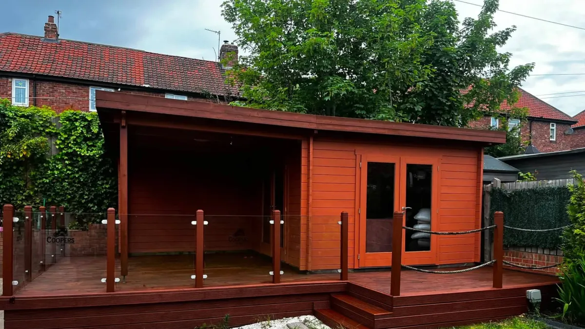 Timber garden room and decking stained red-brown